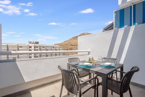 a table and chairs on a balcony with a view at Patalavaca Beach, One Bedroom Apartment in Patalavaca