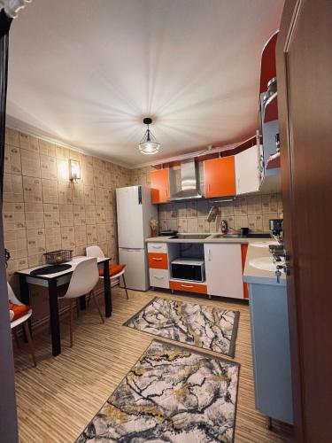 a kitchen with orange and white appliances and a table at RYD HOUSE Bucovina in Frumosu