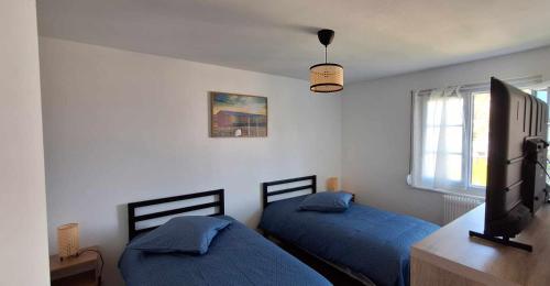 - une chambre avec 2 lits, une télévision et une fenêtre dans l'établissement Villa Berckarosse, à Berck-sur-Mer