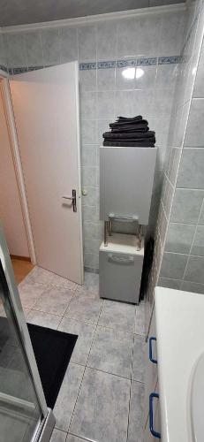 La salle de bains est pourvue de toilettes et de serviettes sur une étagère. dans l'établissement Villa Berckarosse, à Berck-sur-Mer