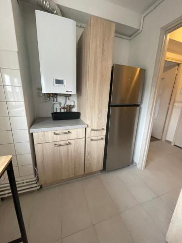a kitchen with a stainless steel refrigerator and white cabinets at Appartement Le Bleu Vert Béthunois in Béthune