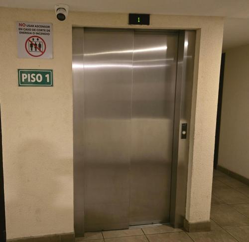 a metal elevator door in a building with a sign at The king inn Habitacion # 3 Estadia por habitacion in Guatemala