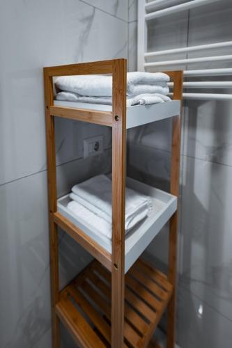 a wooden shelf with white towels in a bathroom at Escape Studio Pollux Militari in Dudu