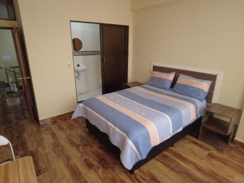 a bedroom with a bed and a bathroom with a shower at GOLDEN DREAMS in Callampaya