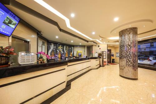 a bar in a restaurant with a counter at Bosheng International Hotel Guangzhou Baiyun International Airport Huadu Plaza Branch - Free Deliver Service to Guangzhou Baiyun International Airport & Free Deliver Service to Canton Fair Complex During Canton Fair Period in Huadu