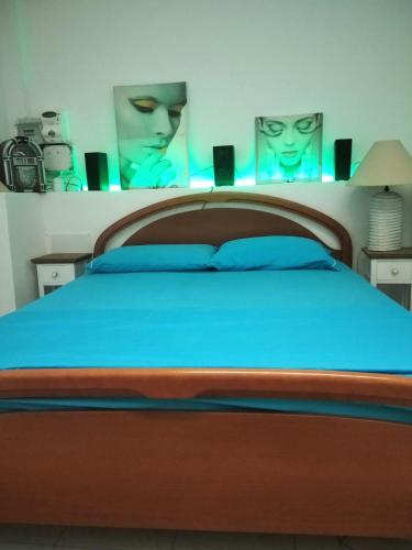 a bedroom with a wooden bed with blue sheets at "HOUSE OF LELLA 2" appartamento 1 camera da letto - M1 METRO ROSSA in Milan