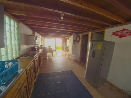 a kitchen with a counter and a refrigerator at Las Cabañas de Mario in Necoclí