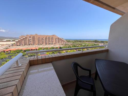 un balcón con mesa y silla y un edificio en ACV - Costa Azahar II-2ª linea planta 6 norte 2, en Oropesa del Mar