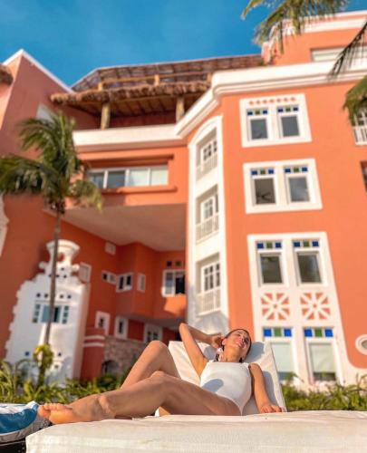 a woman laying on a lounge chair in front of a house at Casa Tortugas Boutique Hotel - A Hidden Gem in Cancun in Cancún