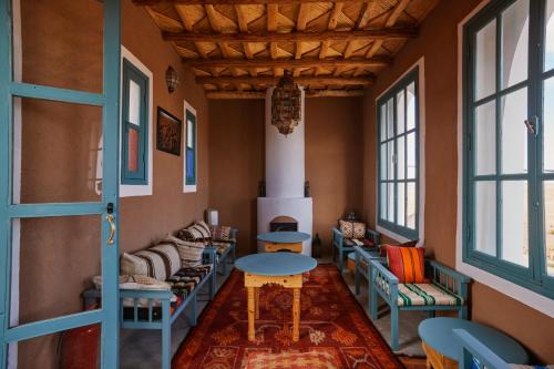 a room with chairs and a table and windows at Agafay Desert Hotel in El Karia