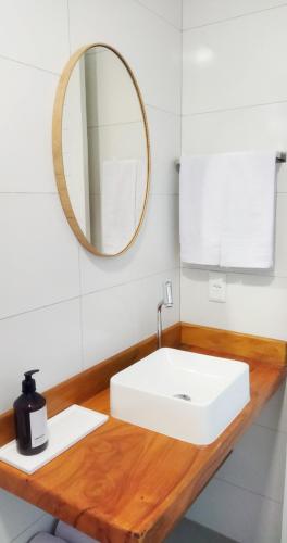 a bathroom with a white sink and a mirror at Pousada Fenícia in Japaratinga