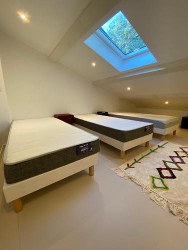 - 2 lits dans une chambre avec une lucarne dans l'établissement villa Bikini Bormes les mimosas, à Bormes-les-Mimosas