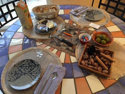 een tafel met borden en kommen met eten erop bij Villa Bellevue chambre d'hôtes in Siorac-en-Périgord