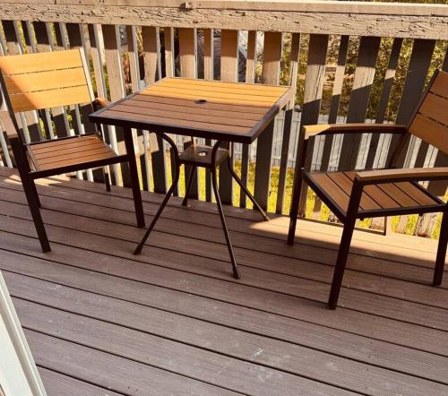 a wooden table and two chairs on a deck at Executive upper floor apartment 10 in Fairbanks
