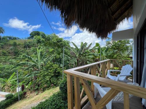 a porch with two chairs and a view of the forest at Villa Tierrita in Santa Bárbara de Samaná