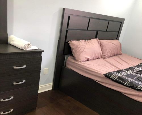 a bed with a black headboard next to a dresser at SHAY 2ND FLOOR-Holiday Home in Pickering