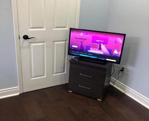 a flat screen tv sitting on a dresser in front of a door at SHAY 2ND FLOOR-Holiday Home in Pickering