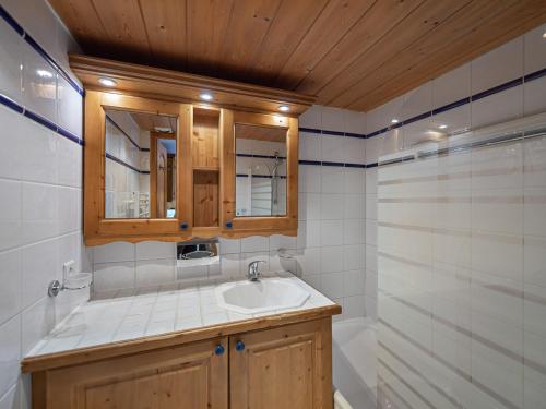 une salle de bain avec un lavabo, un miroir et une baignoire dans l'établissement Appartement ski aux pieds avec piscine, spa et terrasse ensoleillée à Méribel Village - FR-1-566-57, à Les Allues