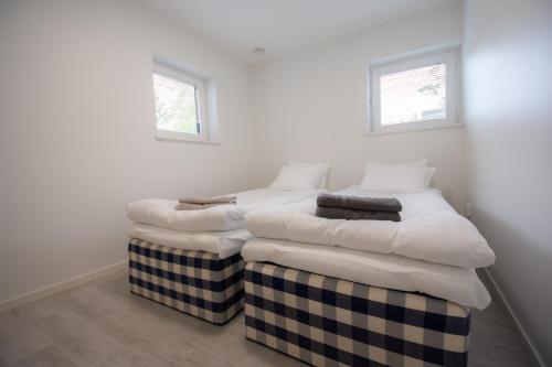two twin beds in a room with two windows at Krok in Värmdö