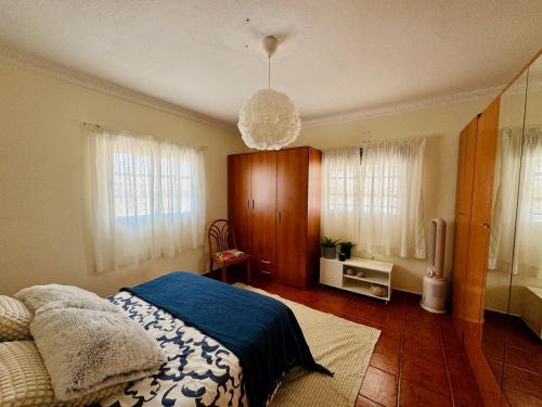 a bedroom with a bed and a chandelier at Apartamento as Lombas in Cardón