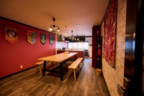 a dining room with a wooden table and a kitchen at Harry Potter Osaka HogwartsSchool哈利波特 魔法学院 in Osaka