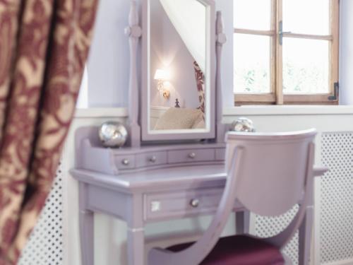 a white dressing table with a mirror and a chair at Schloss Thalheim in Sankt Pölten