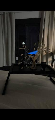 une table avec un bouquet d'objets au-dessus d'un lit dans l'établissement La suite iris, à Nîmes