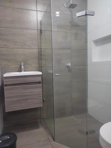 a glass shower with a sink and a toilet at Cabaña con aire acondicionado San Jeronimo in San Jerónimo