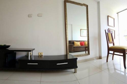 a living room with a table and a mirror at Vivienda Céntrica y Acogedora in Sabaneta