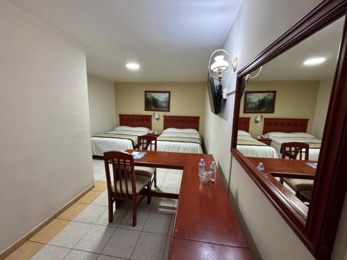 a room with several beds and a table and chairs at Hotel NV in Guadalajara
