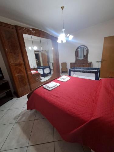 a bedroom with a red bed with two towels on it at Casa San Francesco in Mondragone