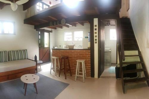 a living room with a couch and a kitchen at Loft situado a 700 metros da praia de Boiçucanga in Boicucanga