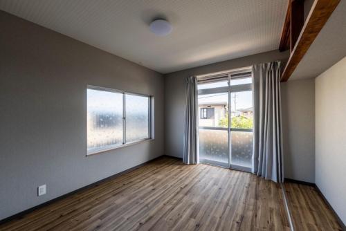 an empty room with a large window and wooden floors at Oyado Yadokari - Vacation STAY 92325v in Anan