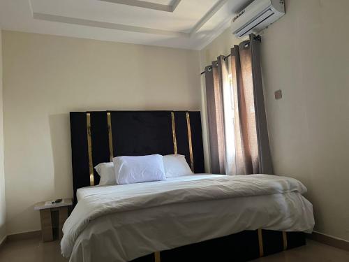 a bedroom with a large bed with a black headboard at YP-Made Luxurious 1 & 2 Bedroom Apartments in Eluju