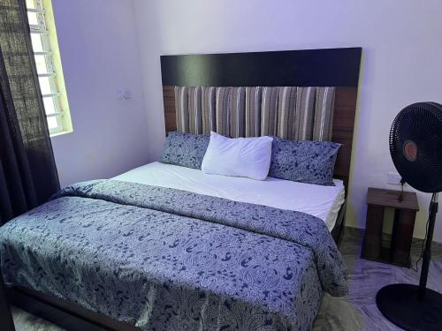 a bedroom with a bed with a blue comforter at YP-Made Luxurious 1 & 2 Bedroom Apartments in Eluju