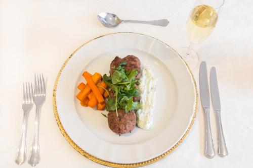 a plate of food with meatballs and carrots on a table at The Syrene Boutique Hotel in Johannesburg