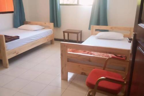 a bedroom with two bunk beds and a red chair at Margaret's House in Moshi