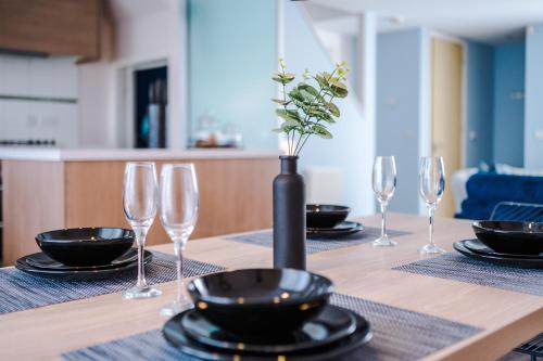 a table with wine glasses and a vase on it at Luxury City Stay Coop Live & Etihad with Free Parking in Manchester