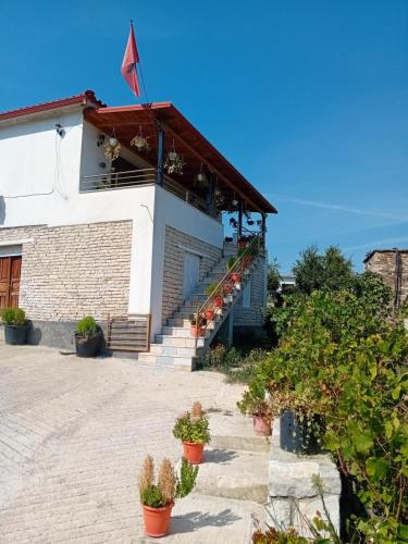 a building with stairs and potted plants in front of it at Villa Rexho in Berat