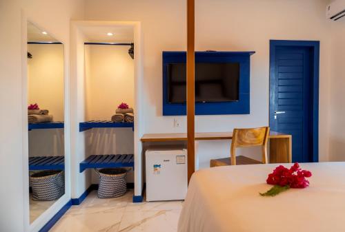 a room with a table with a flower on it at Vila Gallina Pousada in Jericoacoara