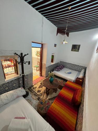 a living room with a bed and a couch at Dar Enouiina in Fez