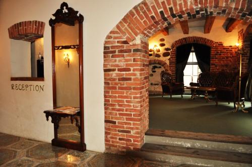 a room with a brick wall and a mirror at St. Peterburg in Pärnu