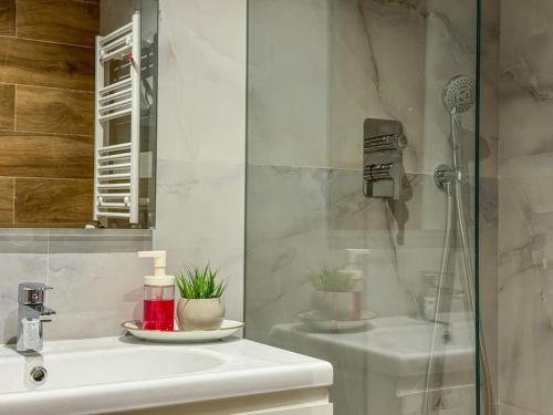 a white bathroom with a shower and a sink at La Conquista à Tunis in Jafar