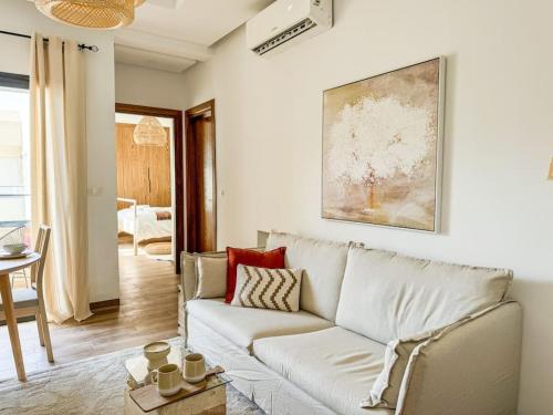 a living room with a white couch and a painting at La Conquista à Tunis in Jafar