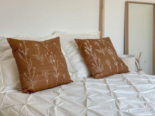 a white bed with two brown pillows on it at La Conquista à Tunis in Jafar