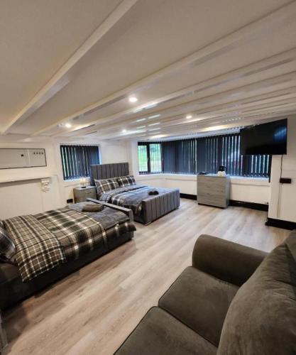 a large living room with two beds and a couch at Rainsough Cottage Guest House - Sleeps upto 8 with ensuite - Free Parking & WiFi in Manchester