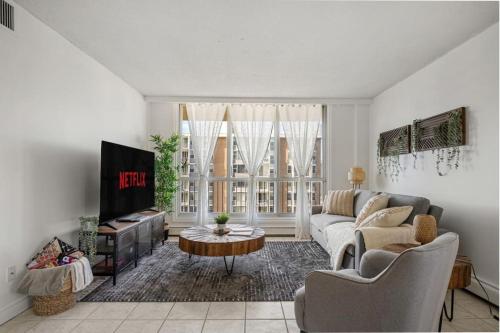 a living room with a couch and a tv at Downtown Near Rogers Place with Covered Parking, Sleeps 6, Pool Table, Sauna, Gym, Two Bedrooms & More in Edmonton
