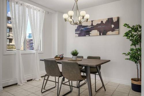 a dining room with a wooden table and chairs at Downtown Near Rogers Place with Covered Parking, Sleeps 6, Pool Table, Sauna, Gym, Two Bedrooms & More in Edmonton