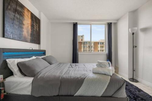 a bedroom with a large bed and a window at Downtown Near Rogers Place with Covered Parking, Sleeps 6, Pool Table, Sauna, Gym, Two Bedrooms & More in Edmonton