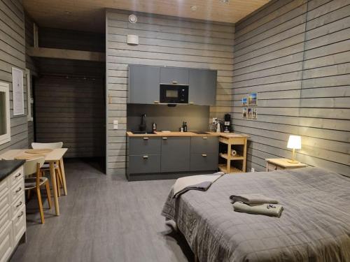 a bedroom with a bed and a kitchen with a counter at Idyllinen vanha navetta Vanhassa Raumassa in Rauma